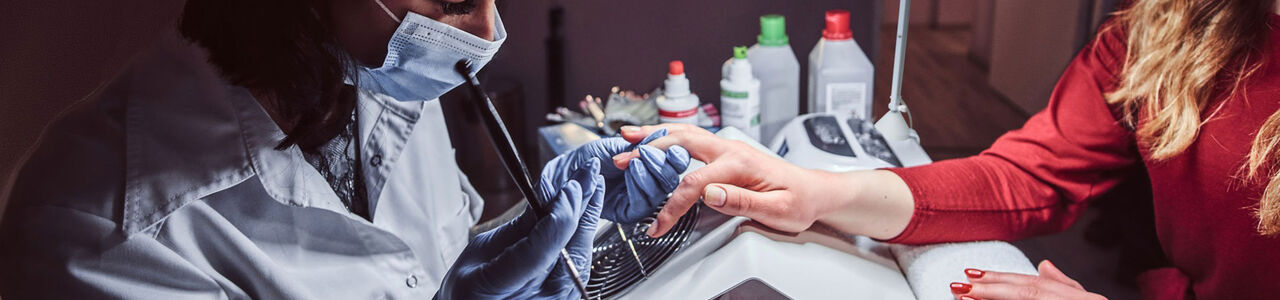 Nagelstyliste die gel aanbrengt op de nagels van een klant in een professionele salon, symbool voor veilige en conforme nagelbehandelingen volgens EU-regels.