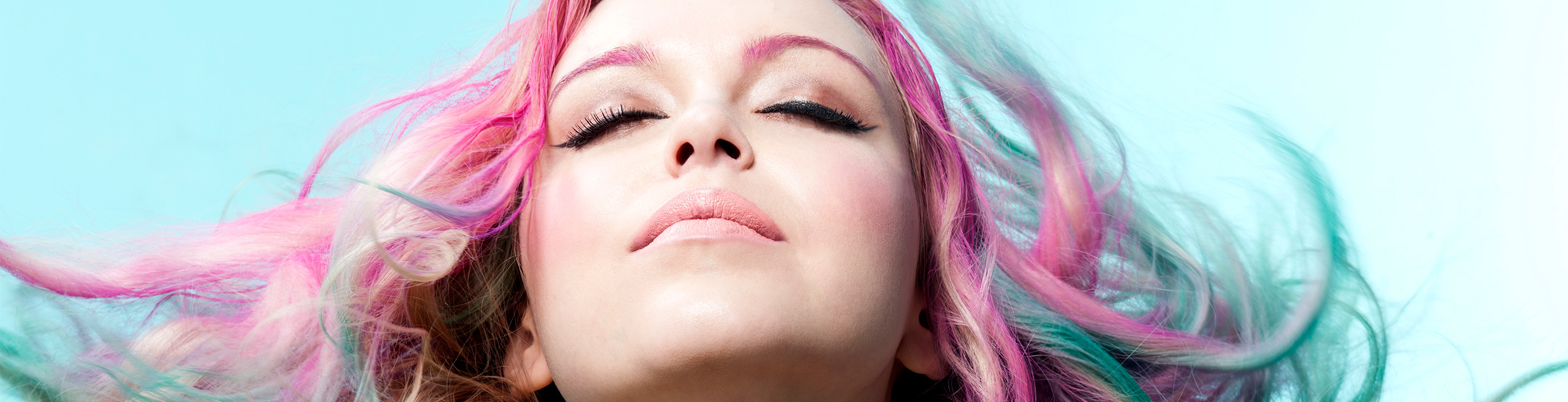 Woman with vibrant pink hair, illustrating the results of applying permanent hair dye at home.
